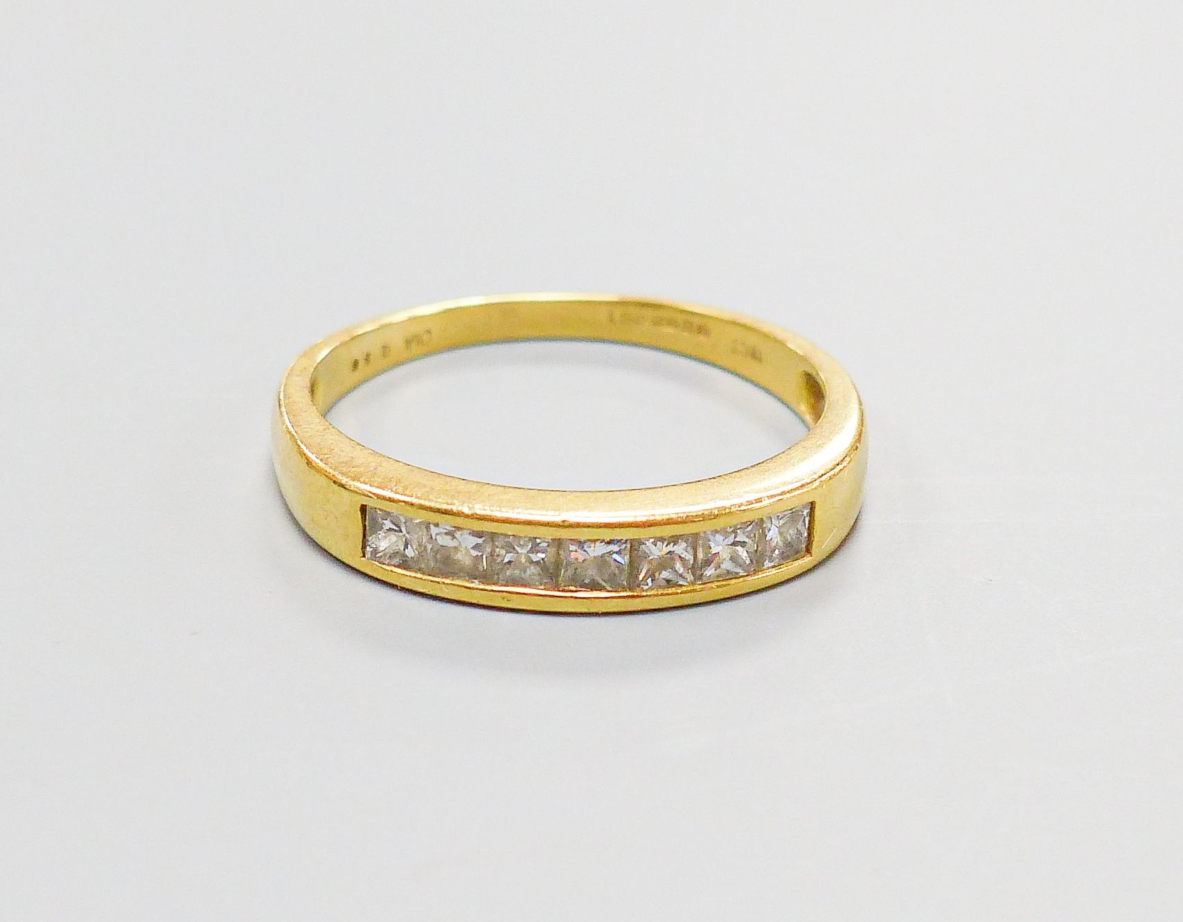 A modern 18ct gold and channel set seven stone diamond half hoop ring, size P, gross weight 2.8 grams.